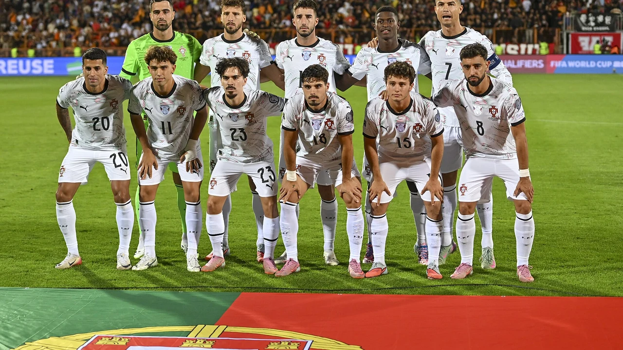 Jogadores da Seleção portuguesa alinhados para a fotografia de equipa antes de um jogo, com as bancadas cheias ao fundo